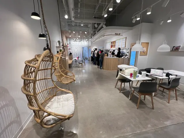 Hanging rattan chairs and the order counter inside Pure Green The Woodlands