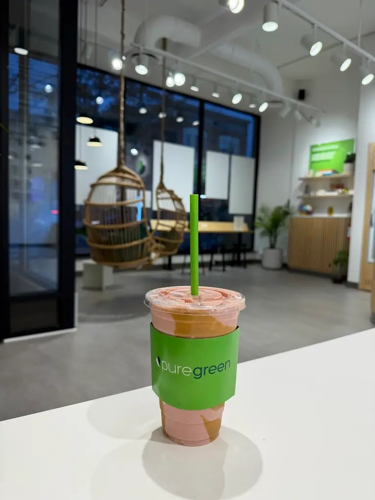 A smoothie on the table with hanging rattan chairs behind at Pure Green Montclair
