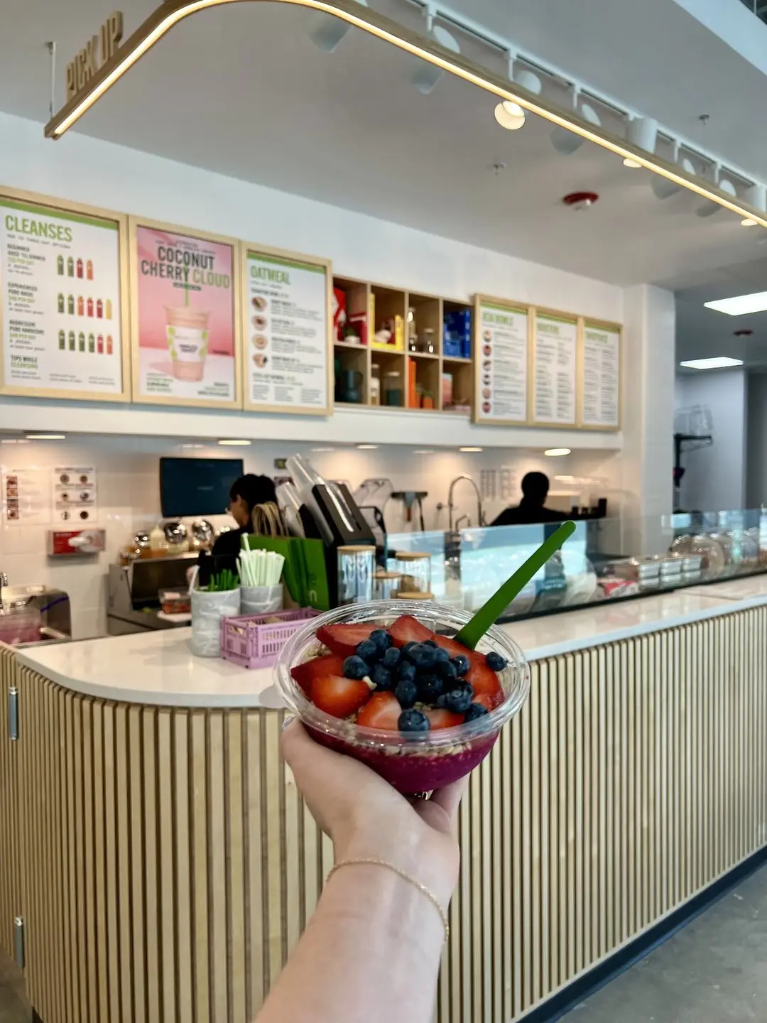 Guest holding an acai bowl at the Pure Green Capitol Square counter