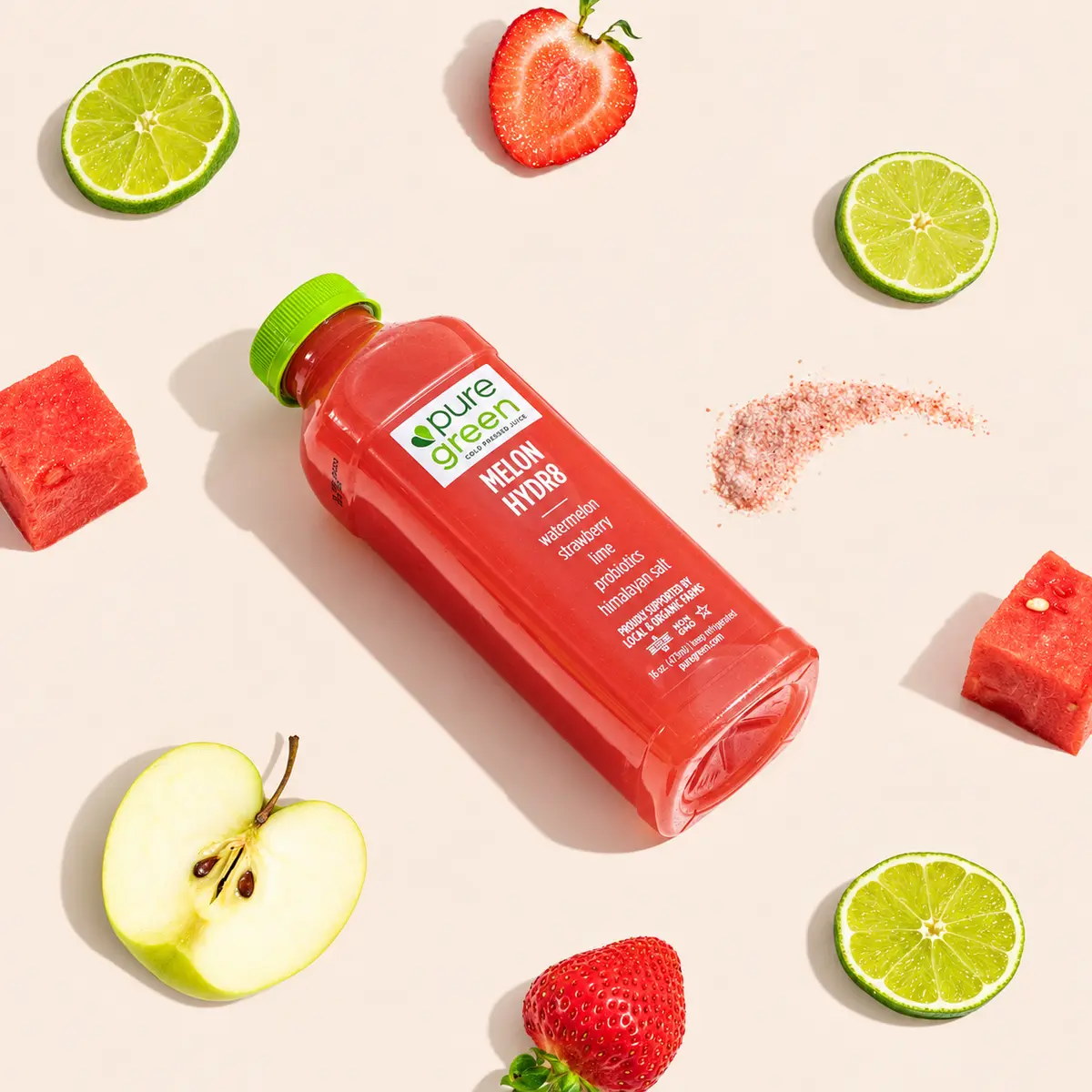 Pure Green Melon Hydr8 juice surrounded by watermelon, lime, strawberries, and apple