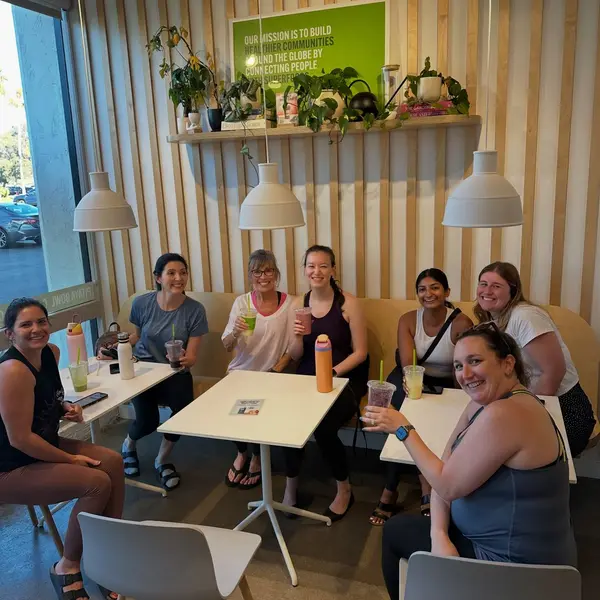 Group of guests enjoying smoothies at a table inside Pure Green Carlsbad