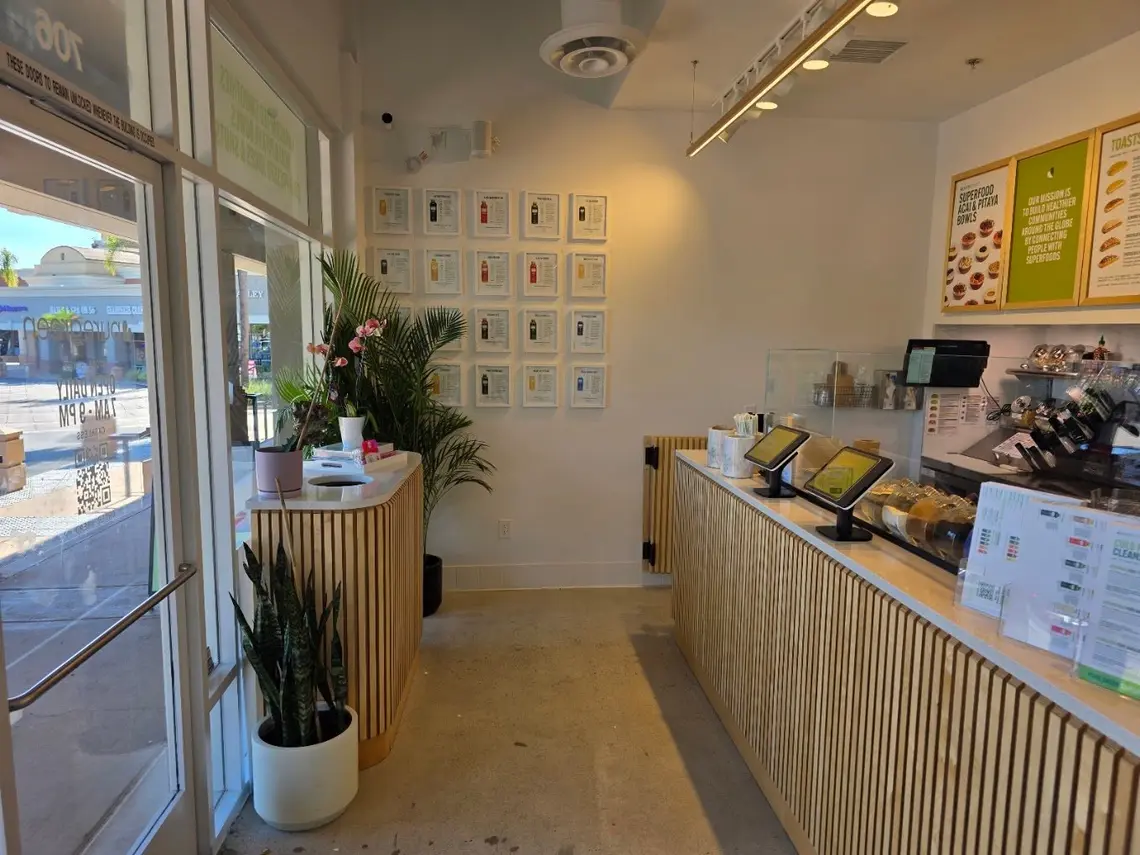 Inside Pure Green Carmel Valley with self-order screens along the wood-slat counter