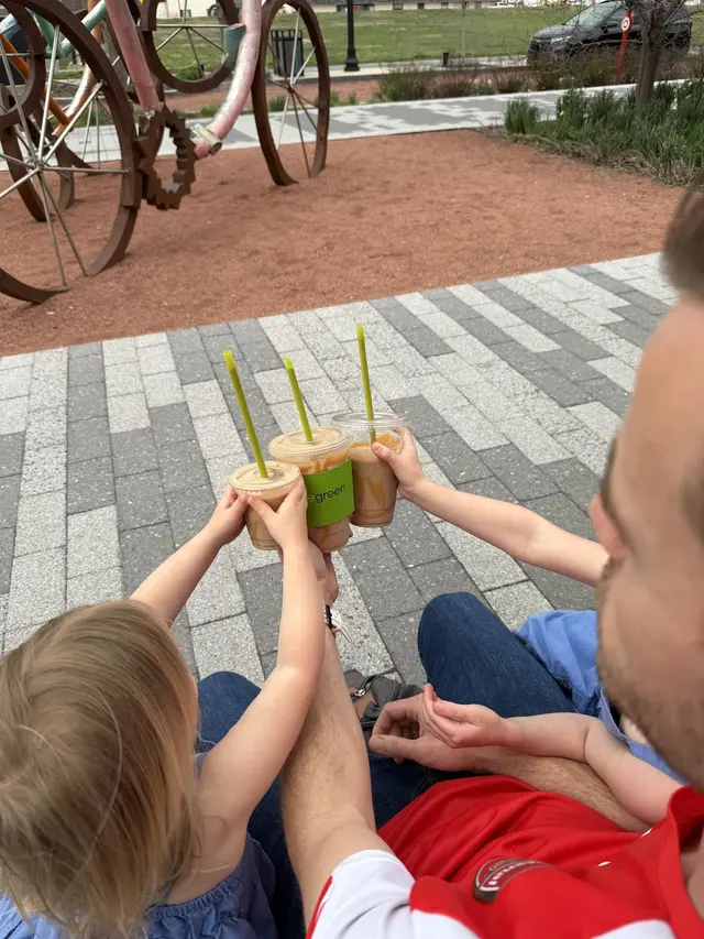 Green smoothies raised in a toast outside Pure Green Midtown Carmel