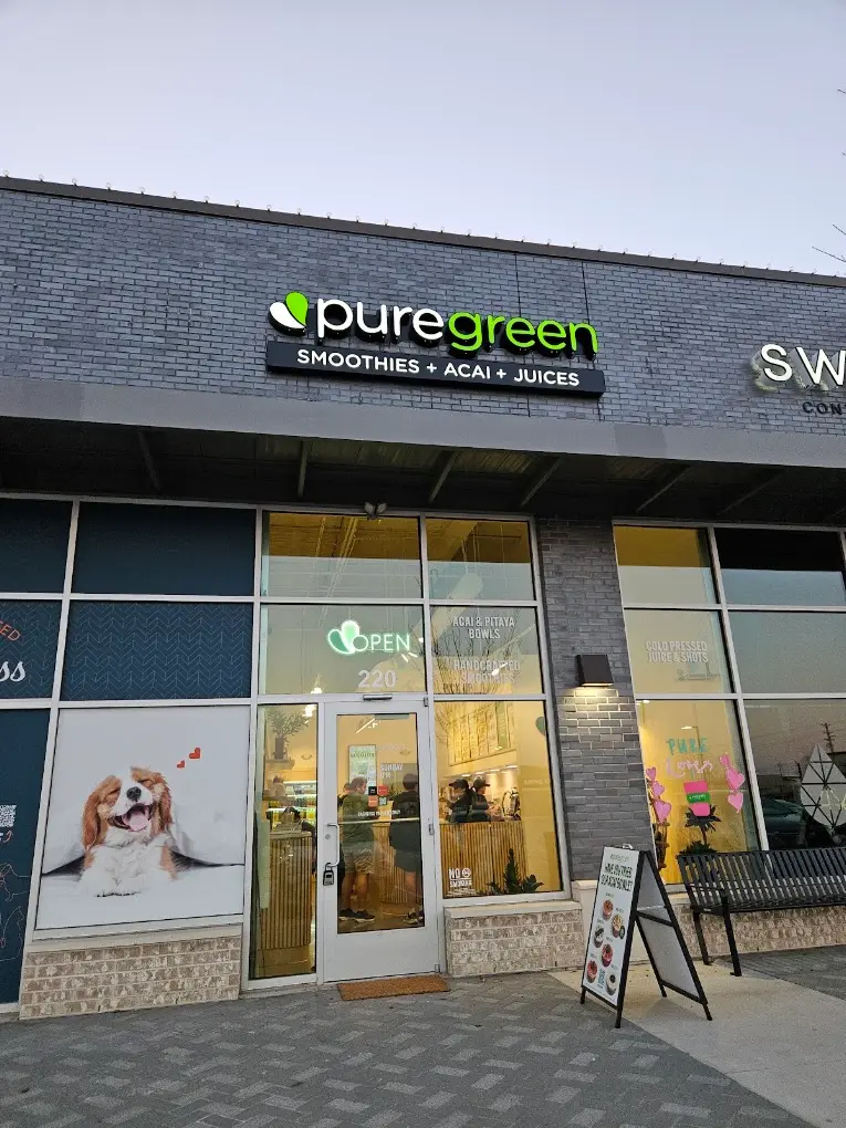 The lit shopfront of Pure Green Frisco on Eldorado Parkway at dusk