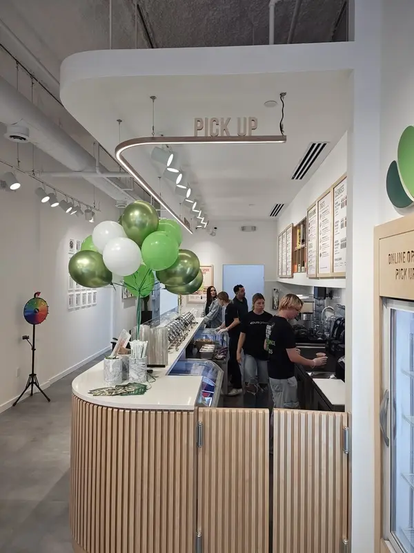 Inside Pure Green SLO with green balloons and the pickup counter on opening day
