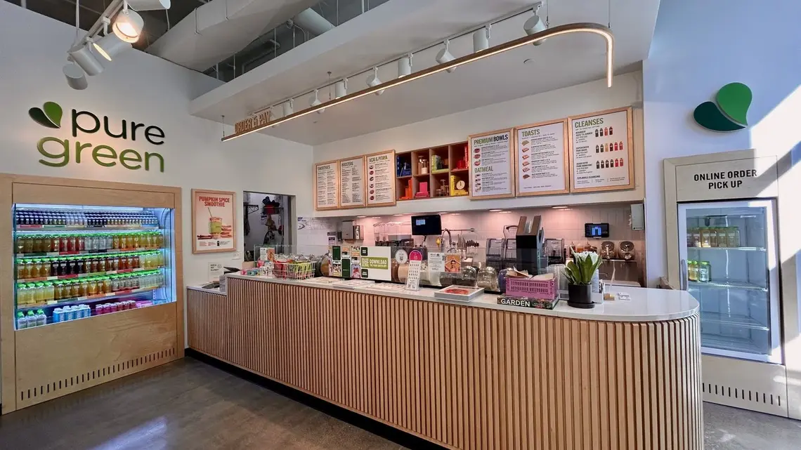 The order counter and cold-pressed juice fridge inside Pure Green Fishers