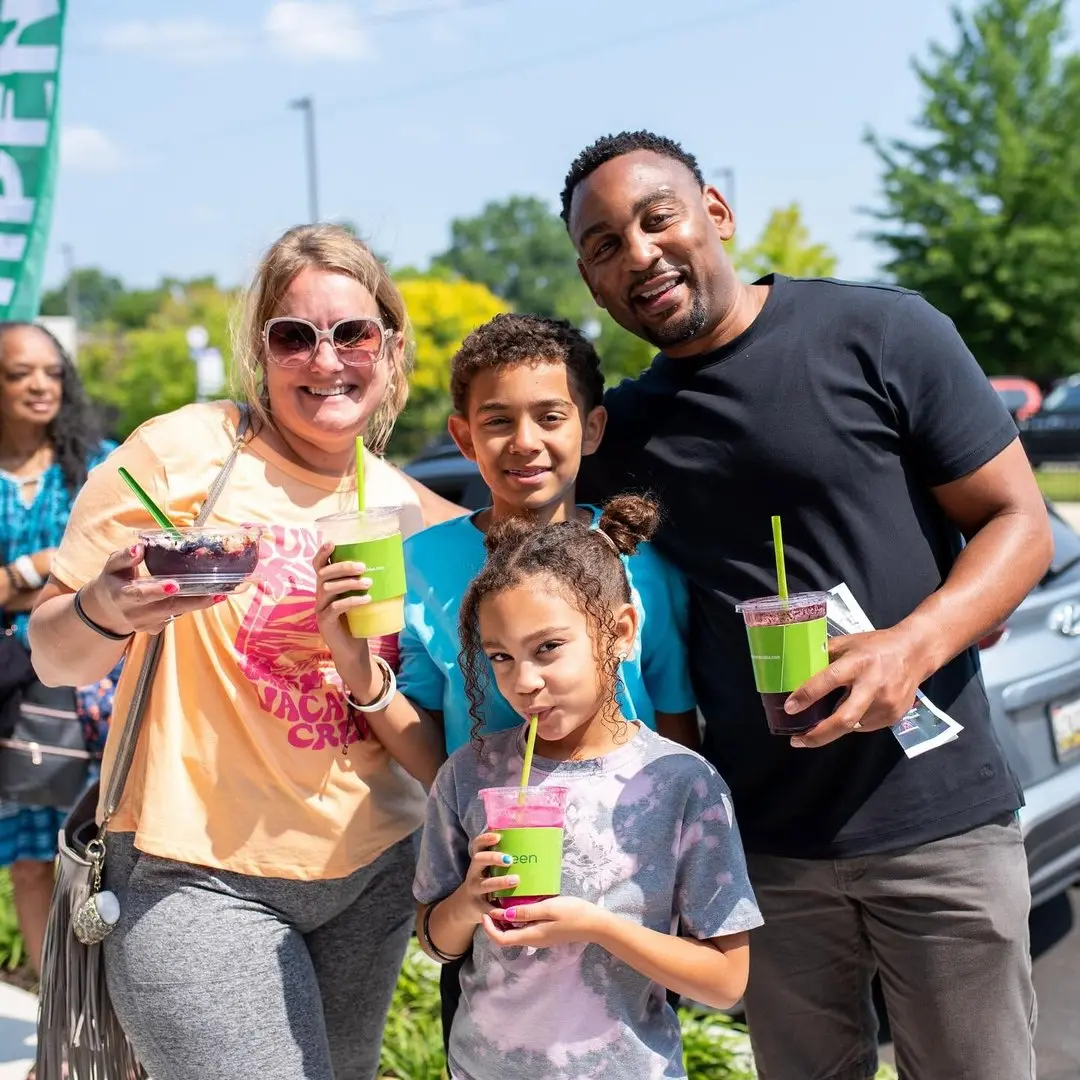 Family enjoying green smoothies outside Pure Green Carytown Exchange