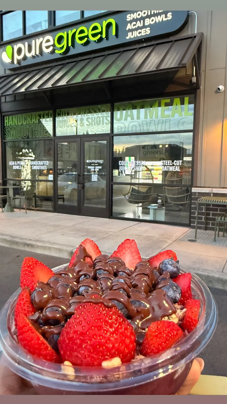 An acai bowl held up outside Pure Green Cedar Mill on Northwest Cornell Road