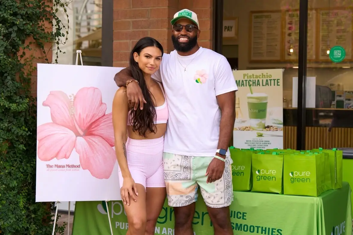 Guests beside a Pure Green community event display.