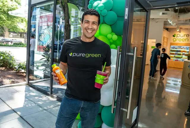 Team member holding fresh juices at the Pure Green Downtown Seattle entrance