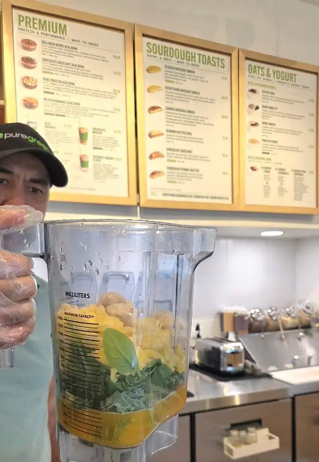 A smoothie being blended behind the Pure Green Naperville counter