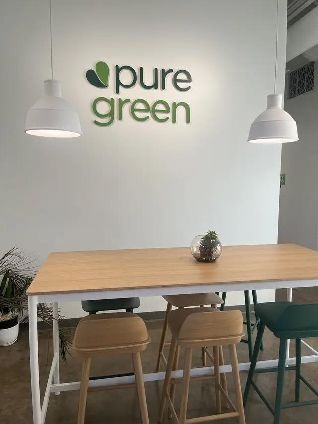Inside Pure Green Tempe showing the pure green wall logo and communal seating