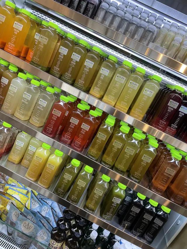 Rows of cold-pressed juice in the fridge at Pure Green South Barrington