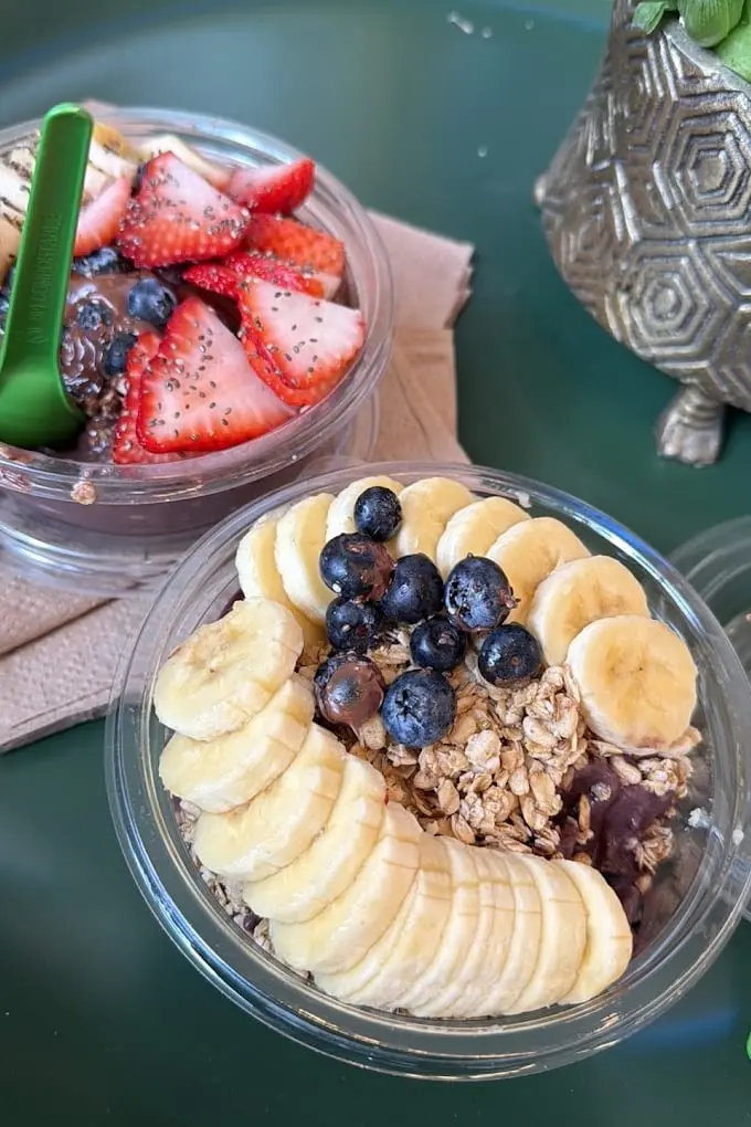 Two acai bowls topped with strawberries, blueberries and granola at Pure Green Washington Heights
