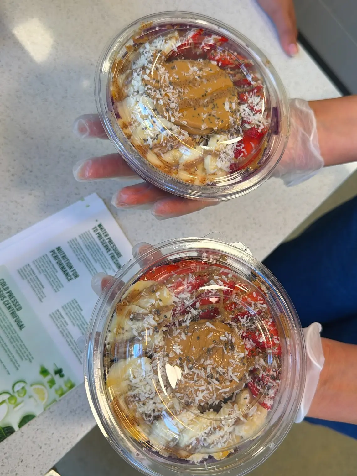 Two acai bowls topped with peanut butter, coconut and chia at Pure Green Tysons