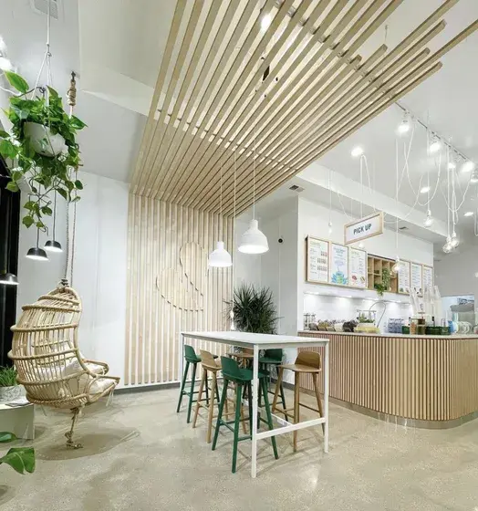 Inside a Pure Green store: the wood-slat counter, hanging chair and menu boards