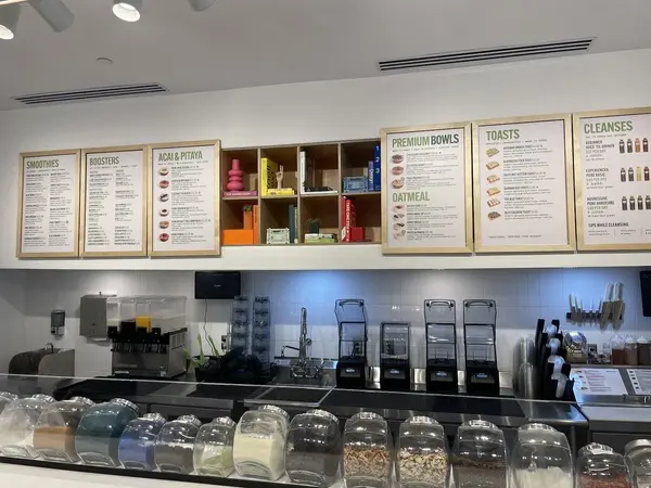 Menu boards and topping station behind the counter at Pure Green SLO