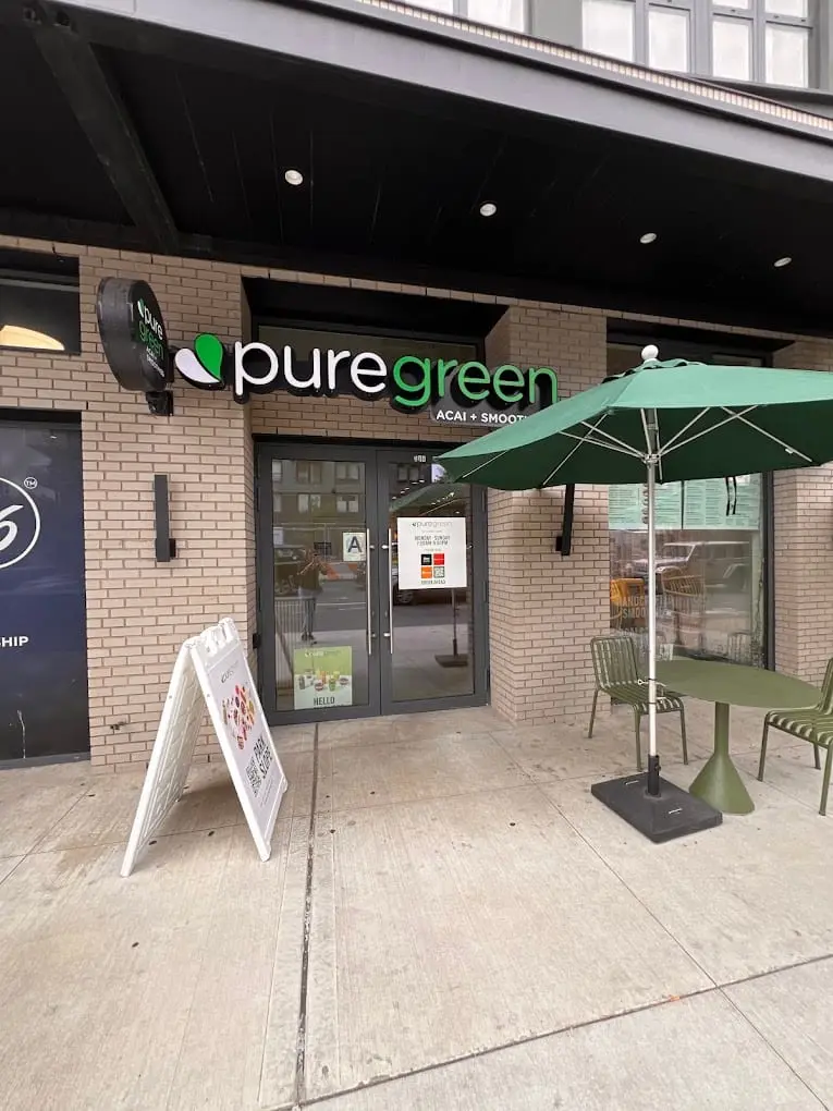Pure Green Park Slope shopfront on Fourth Avenue with outdoor seating under an umbrella