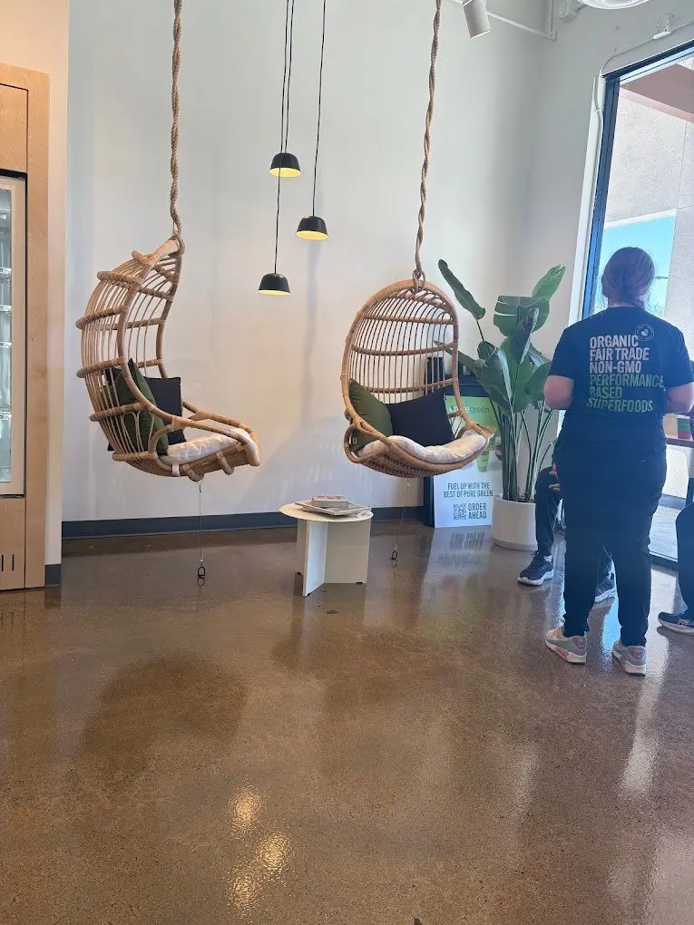 Hanging rattan chairs and pendant lights in the seating area inside Pure Green Granite Bay