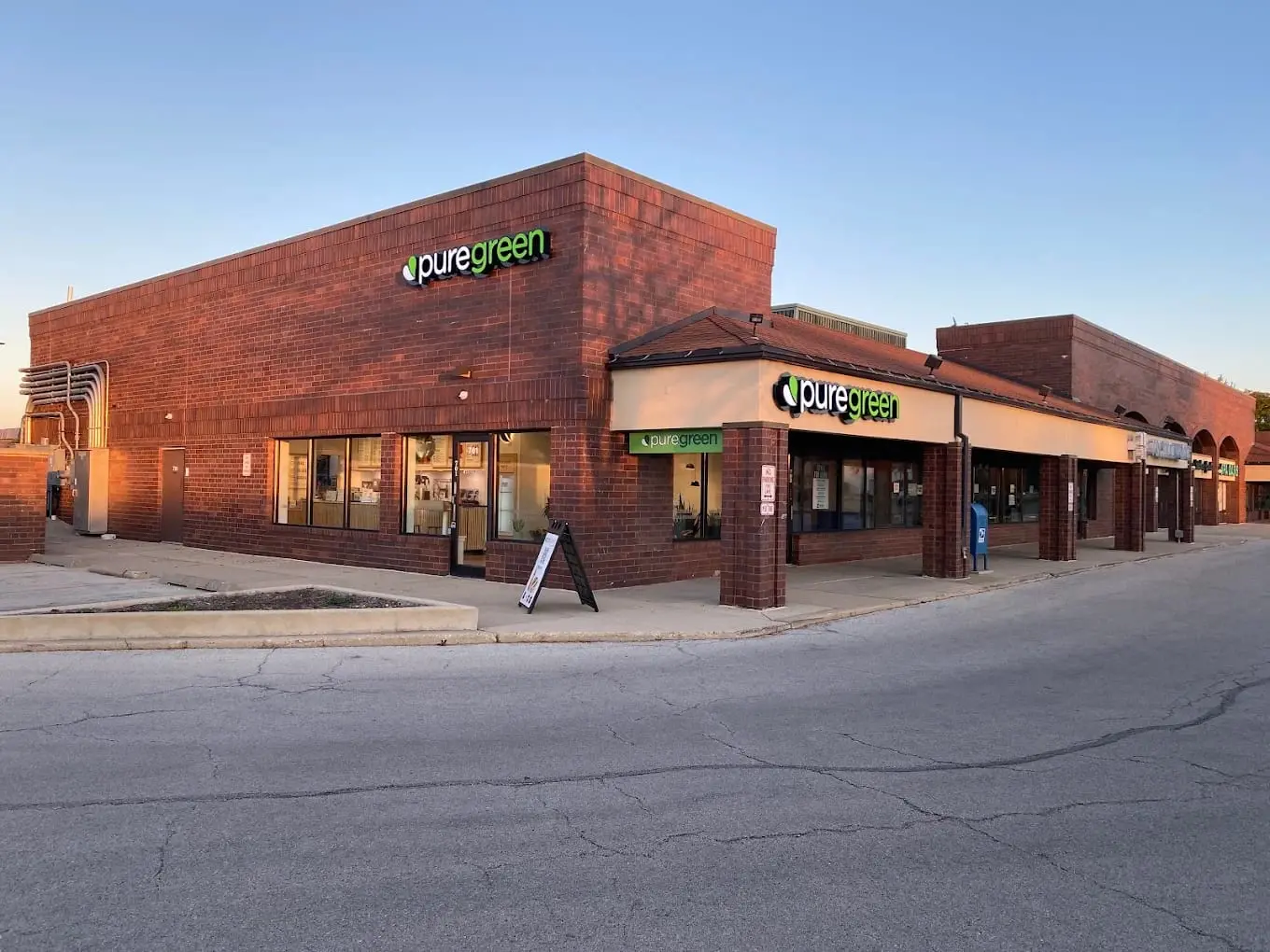 Pure Green Naperville storefront on East Ogden Avenue at sunset