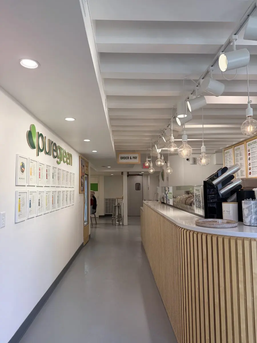 The long wood-slat counter and menu wall inside Pure Green Dupont Circle