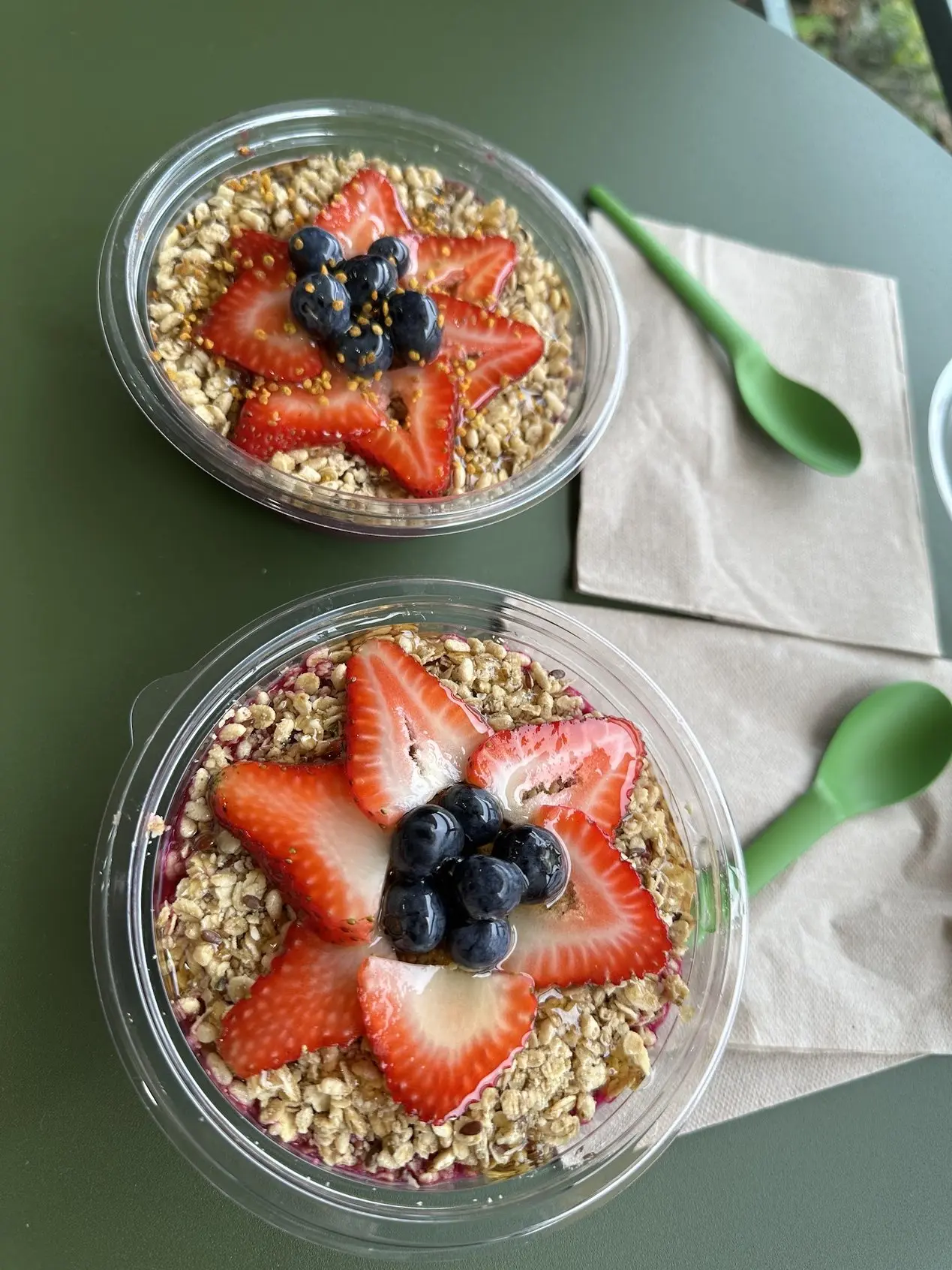 Two acai bowls topped with strawberries and blueberries at Pure Green Columbia