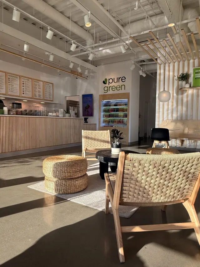 Woven chairs and a low table in the seating area at Pure Green Cedar Mill