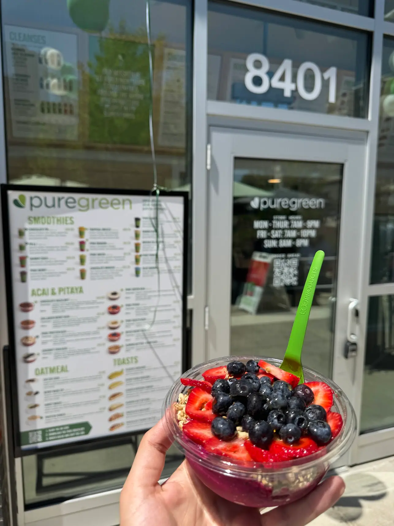 An acai bowl held outside the entrance to Pure Green Tysons