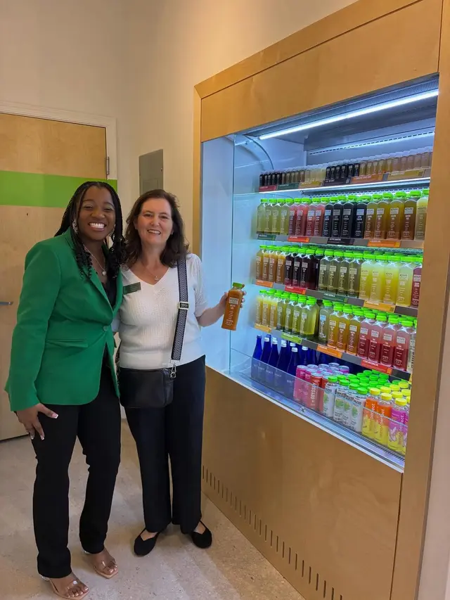 Two guests beside the cold-pressed juice fridge at Pure Green Boynton Beach
