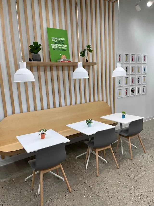 Tables and chairs beside the slatted wall at Pure Green Sterling Heights