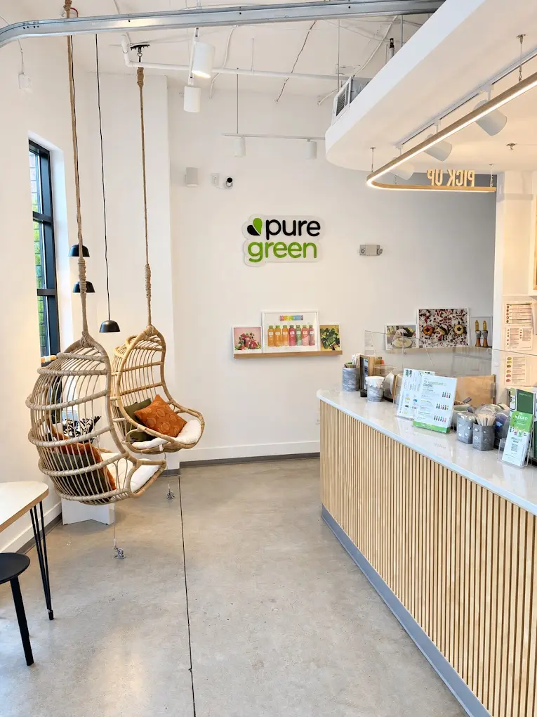 Hanging rattan chairs and the order counter inside Pure Green NoDa