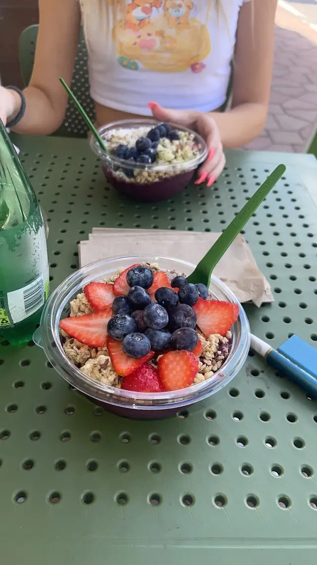 Two acai bowls topped with fresh berries and granola on a table at Pure Green Aventura