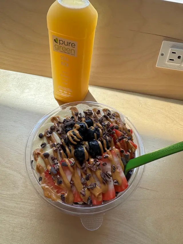 An acai bowl and a bottle of Soul Kick cold-pressed juice at Pure Green NoDa