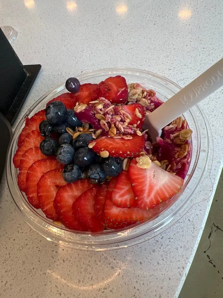 An acai bowl topped with strawberries, blueberries and granola at Pure Green Dean Street
