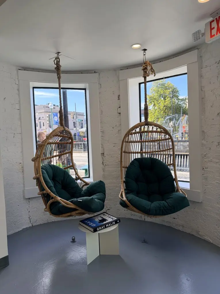 Two hanging rattan chairs in the front windows at Pure Green Dupont Circle