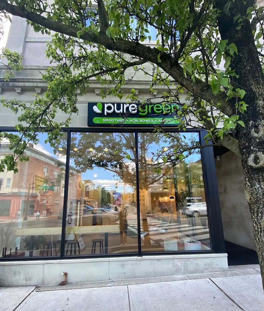 The shopfront of Pure Green Montclair on Bloomfield Avenue, framed by a street tree