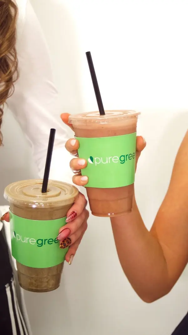 Two Pure Green smoothies held up at Pure Green Madison