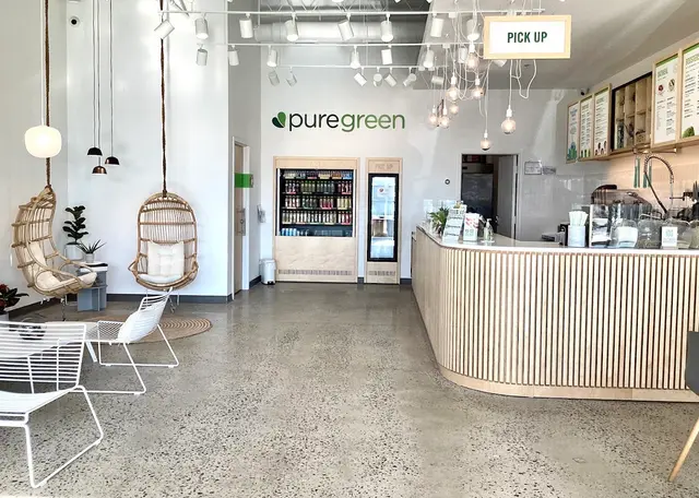Hanging rattan chairs beside the cold-pressed juice fridge at Pure Green Princeton