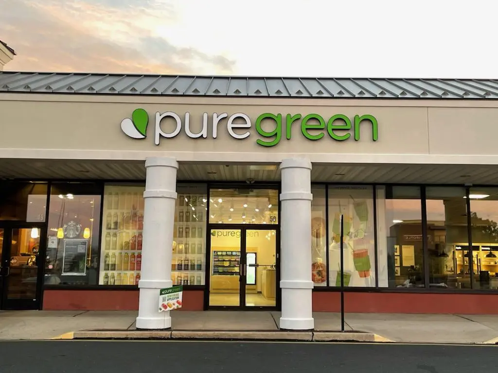 The shopfront of Pure Green Princeton at Mercer Mall at dusk