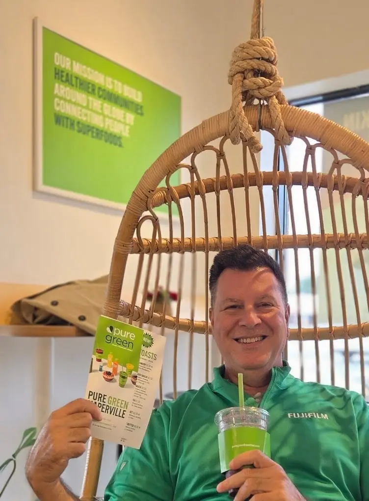 A guest in the hanging chair with a green smoothie at Pure Green Naperville