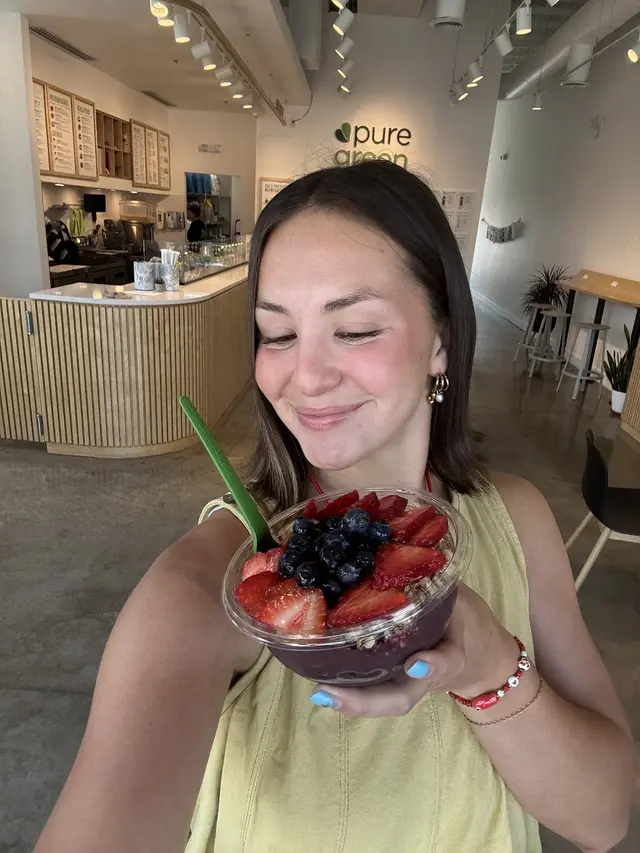 Guest holding an acai bowl at the Pure Green Saratoga Springs counter