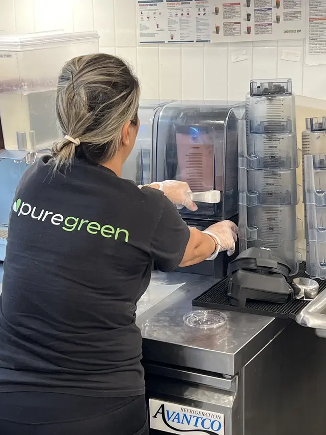 Pure Green Sawgrass Mills team member blending a fresh smoothie