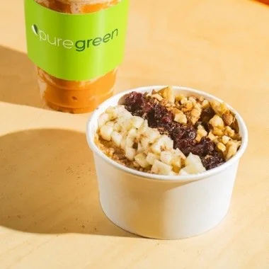 Pure Green Pumpkin Spice Oatmeal Bowl topped with apples, walnuts and cranberries
