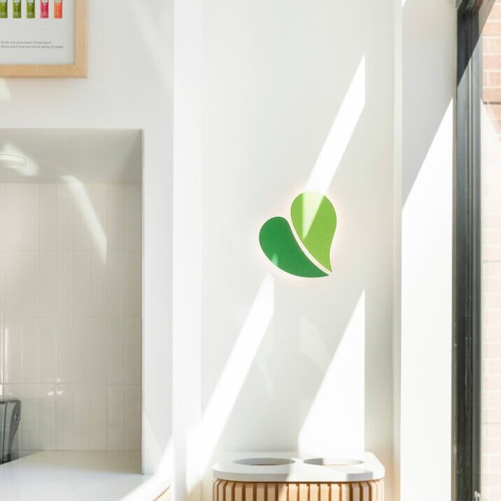 Pure Green leaf logo on a store interior wall