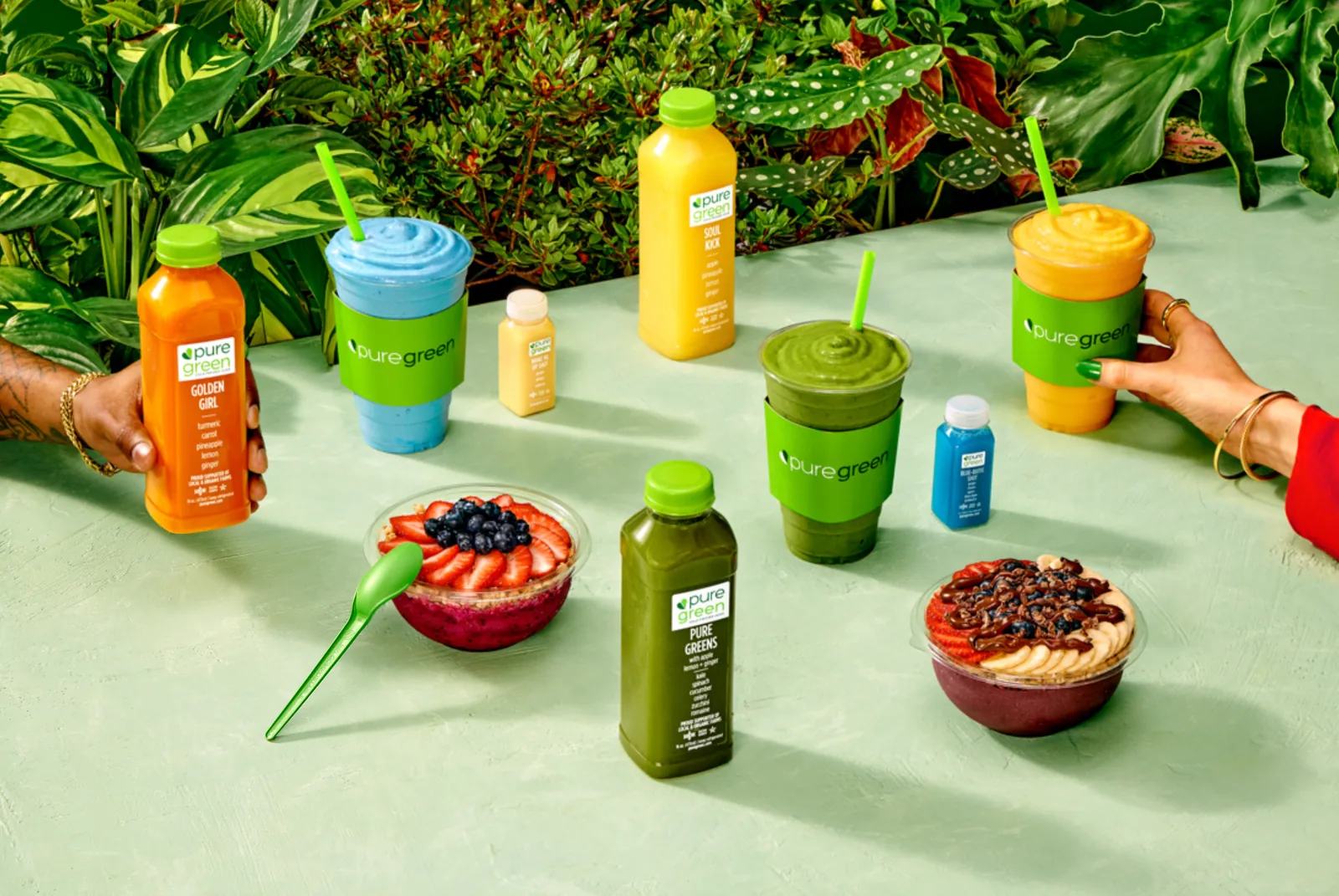 Pure Green smoothies, juices and acai bowls arranged as a product spread