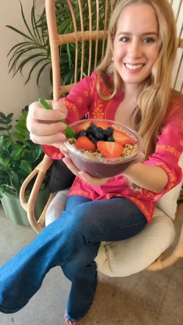 Guest relaxing in the rattan hanging chair with an acai bowl inside Pure Green Arcadia
