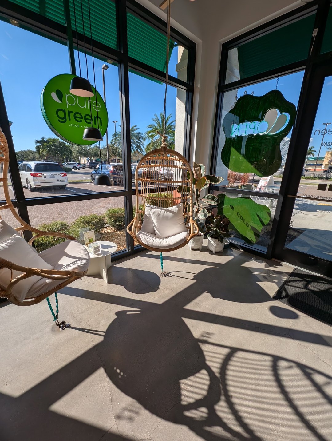 Rattan hanging chairs by the window inside Pure Green Cape Coral