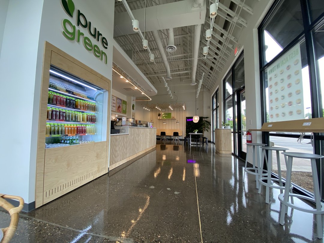 Inside Pure Green Fort Collins showing the juice fridge, counter and seating