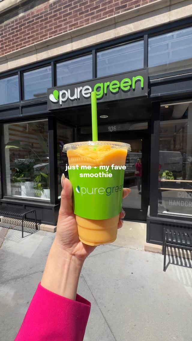 Guest holding a Pure Green smoothie in front of the Fulton Market storefront