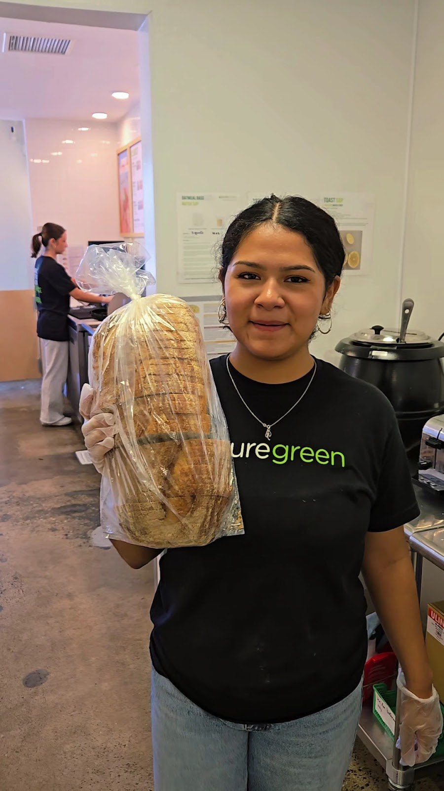 Pure Green Mission Viejo team member holding fresh product behind the counter